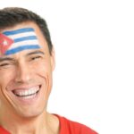 Man with a cuban flag painted on the face smiling