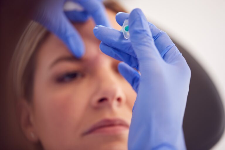 Woman Sitting In Chair Being Give Botox Injection Between Eyes By Female Doctor